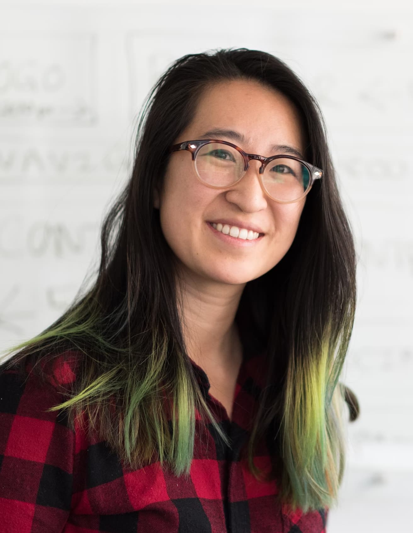 Lorraine Sawicki smiling in a red plaid shirt and tortoise shell glasses